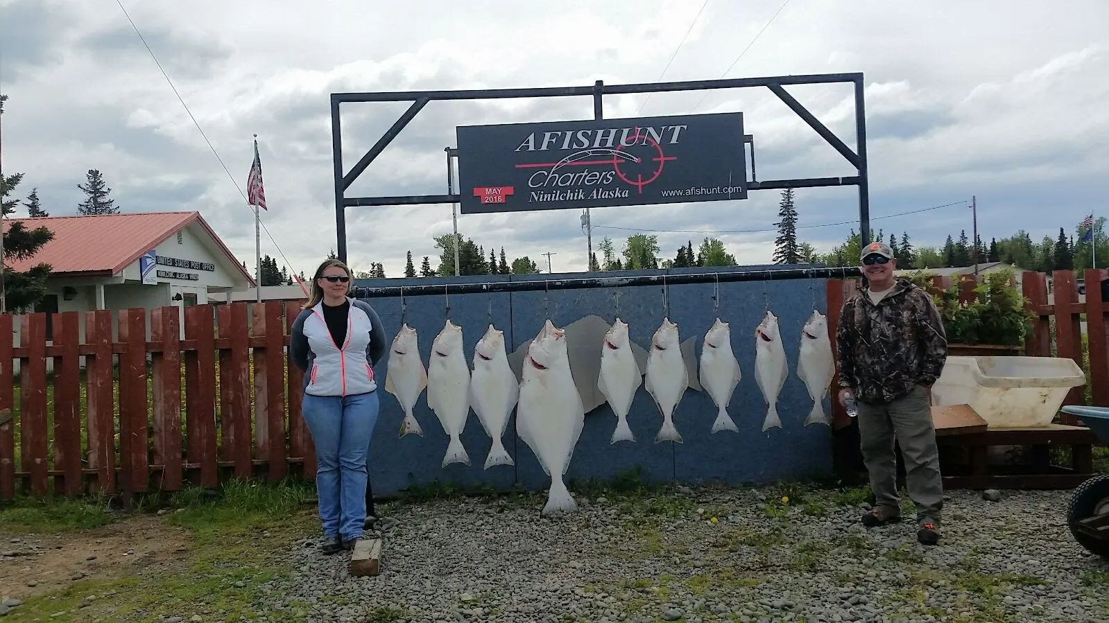 A woman standing next to a sign with fish on it.